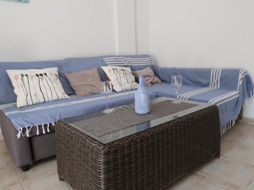 un sofá azul con almohadas y una mesa con copas de vino en Emilia de la Playa, en La Mata