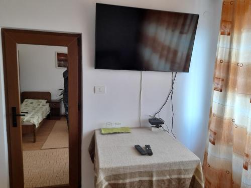 um quarto com uma mesa e uma televisão na parede em Pensiunea Anda em Tulcea