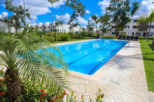 una piscina en un complejo con palmeras en Nuevo Amanecer Cancún, en Cancún