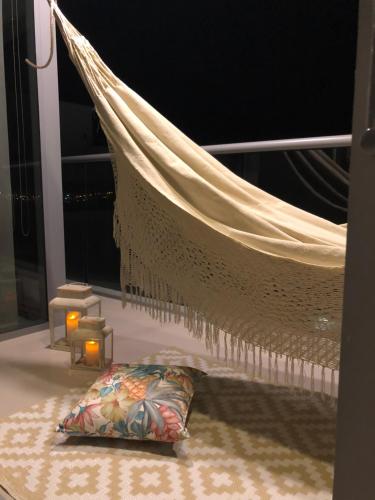 a hammock on a balcony with a pillow and a candle at Namaste Alojamientos Luxury Cartagena in Cartagena de Indias