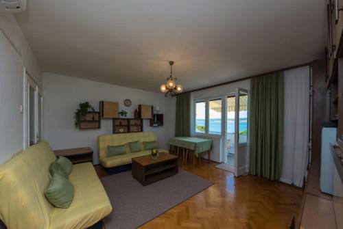 sala de estar con sofá amarillo y mesa en Apartment Romeo, en Crikvenica