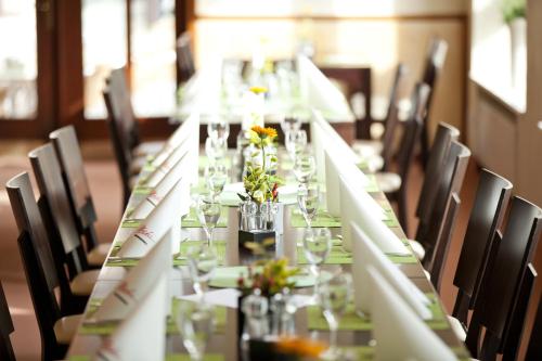 a long table with glasses and flowers on it at NP Hotel Ullrich in Elfershausen