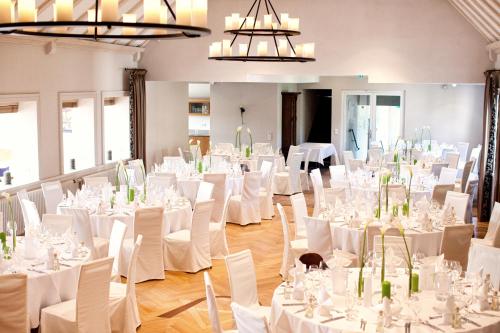 a room full of tables and chairs with white table cloth at NP Hotel Ullrich in Elfershausen