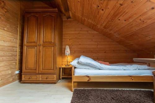 a bedroom with a bed in a wooden room at Pokoje nad Szeszupą Jasionkove DOBRO in Rutka Tartak