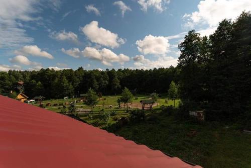a view of a park with a red roof at Pokoje nad Szeszupą Jasionkove DOBRO in Rutka Tartak