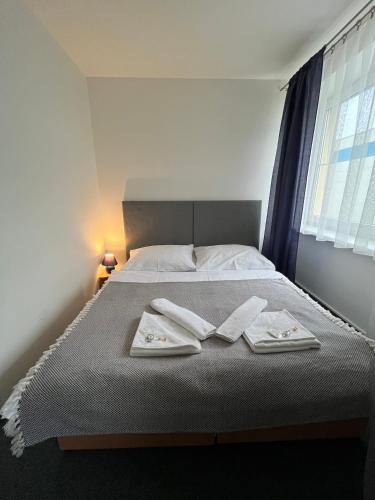 a bedroom with a bed with two towels on it at Garni G Hotel Žilina in Žilina