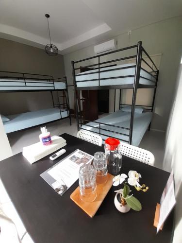 a room with two bunk beds and a table with a tray at SaBi Guest House - Strategic Family -married couples only- Hostel in Prawirotaman in Yogyakarta
