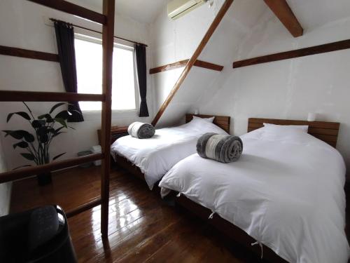 2 camas individuais num quarto com uma janela em Keimichi Guest House em Hakuba