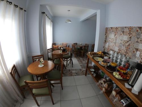 a dining room with tables and chairs and a table with food at Hotel e Pousada Magic in Penha