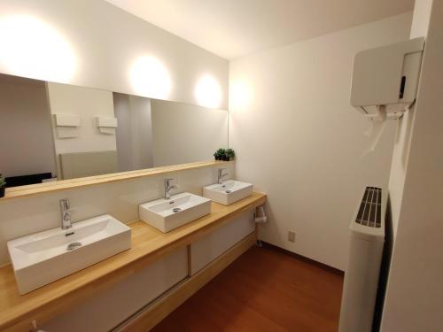 baño con 2 lavabos y espejo grande en Keimichi Guest House, en Hakuba