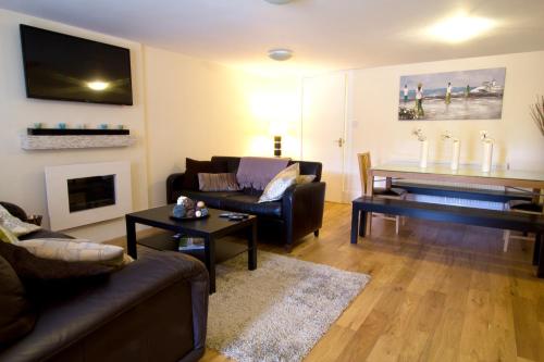 a living room with a couch and a piano at Heritage City - Central New Town Apartment in Edinburgh