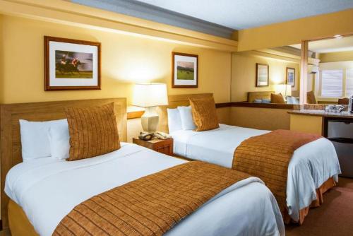 a hotel room with two beds and a bathroom at The Equus in Honolulu