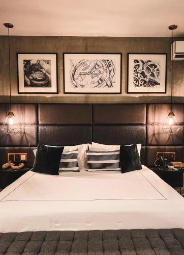 a bedroom with a bed and some pictures on the wall at Diez Diez Collection in Mérida