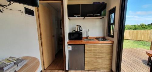 a kitchen in a tiny house with a deck at FLORANVICk incluye 2 bicis!! in Colonia del Sacramento
