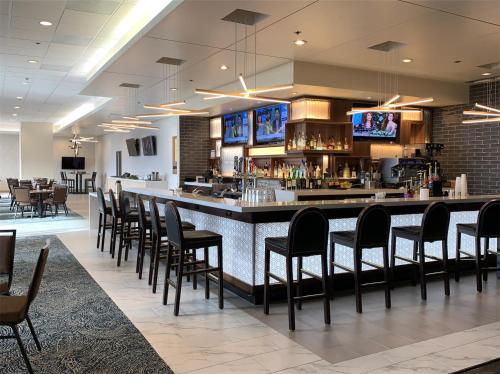 a restaurant with a bar with black chairs at Holiday Inn - Portland - Columbia Riverfront, an IHG Hotel in Portland