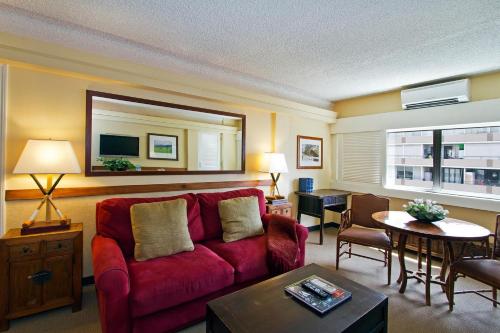 a living room with a red couch and a table at The Equus in Honolulu