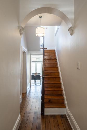 a hallway with a staircase with wood floors and a ceiling at The Governess in Launceston