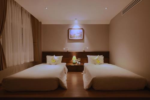 a hotel room with two beds in a room at CHERRY BOUTIQUE HOTEL in Ho Chi Minh City