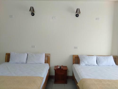 dos camas sentadas una al lado de la otra en una habitación en Khách sạn Sơn, en Thái Nguyên