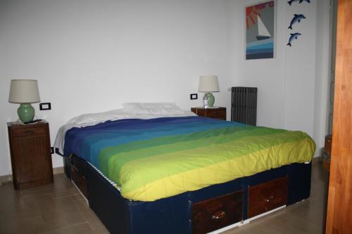 a bedroom with a bed with a colorful blanket at B&B Porta del Mare in Genova