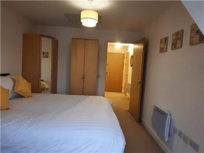 a bedroom with a white bed and a tv at Apartment D505 in Northampton