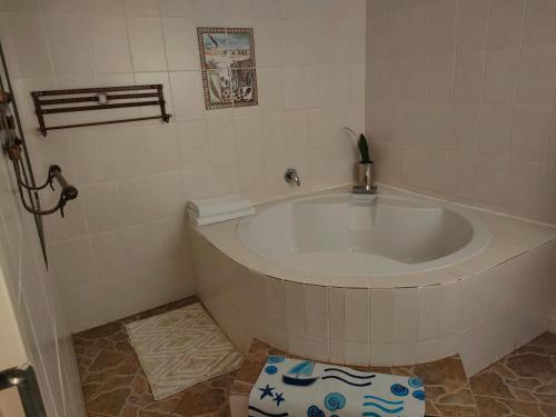 Un baño con una bañera grande en una habitación. en Kea bed and breakfast, en Mogwase