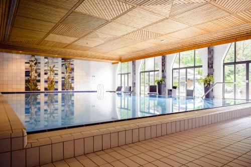duży basen w budynku z oknami w obiekcie Fletcher Hotel Restaurant Epe-Zwolle w mieście Epe