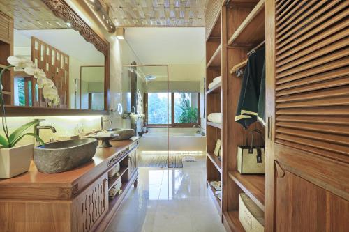 
a kitchen with a sink, cabinets, and a window at The Kayon Jungle Resort in Ubud

