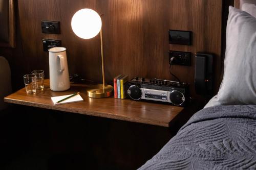 a bedroom with a table with a radio and a bed at The Intrepid Hotel in Wellington