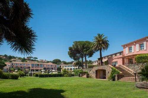 a view of a campus with palm trees and buildings at Hôtel Les Jardins De Sainte-Maxime in Sainte-Maxime