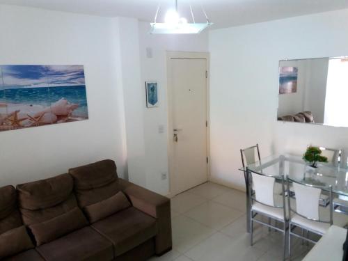 sala de estar con sofá y mesa de cristal en Canasvieiras - Residencial Costa do Mar, en Florianópolis
