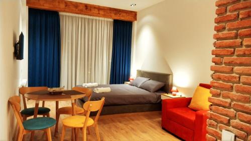 a bedroom with a bed and a table and a couch at Victoria's Panoramic View, ALPIC in Gudauri