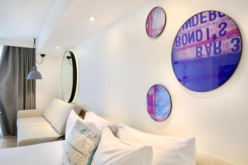 a room with a bed and clocks on the wall at Miss Baker's Boutique Accommodation Bondi in Sydney