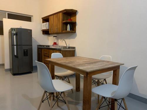 Il comprend une cuisine équipée d'une table en bois et d'un réfrigérateur. dans l'établissement Aloja-T en Apartamento amoblado 4 en Ciudad Bolivar, à Ciudad Bolívar