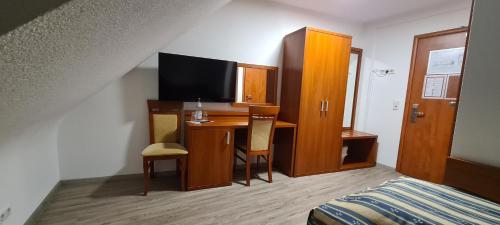 a hotel room with a desk and a bed and a television at M-A-S-Hotel in Stuttgart