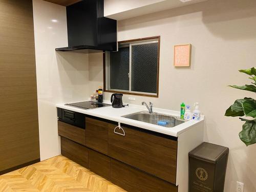 uma cozinha com um lavatório e uma janela em TABISAI HOTEL Suite 博多 em Fukuoka