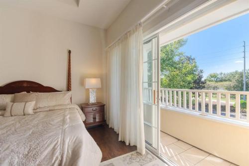 1 dormitorio con 1 cama y balcón con ventana en ELEGANT, COMFORTABLE, INEXPENSIVE... REUNION RESORT en Kissimmee