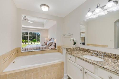 ein Badezimmer mit einer großen Badewanne und einem großen Spiegel in der Unterkunft ELEGANT, COMFORTABLE, INEXPENSIVE... REUNION RESORT in Kissimmee