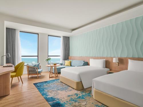 a hotel room with two beds and a desk at Holiday Inn Resort Ho Tram Beach by IHG in Ho Tram