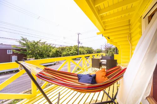 a hammock on the balcony of a house at Awaji Large Log house in Goshiki 2 in Sumoto