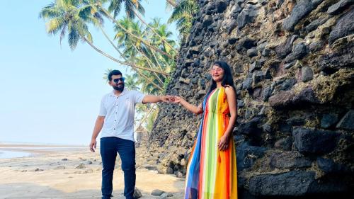 a man and a woman standing on the beach at Tent by the bay, Alibaug Beach Camping, Revdanda in Alibaug