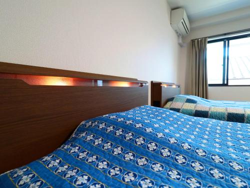 a hotel room with two beds and a window at Izu Kansya in Atami