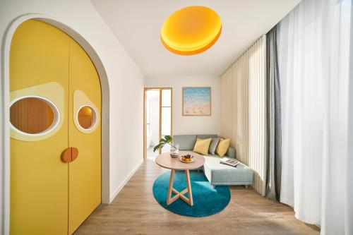 a living room with a yellow door and a table at Holiday Inn Resort Ho Tram Beach by IHG in Ho Tram