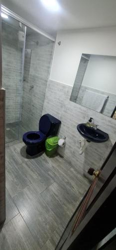 a bathroom with a blue toilet and a sink at Apartamento Ynj#2 in Bogotá