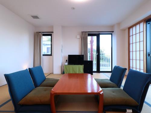 a living room with a couch and a table at Izu Kansya in Atami