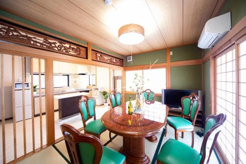 a dining room with a table and chairs at Awaji egaosakuie tonouchi in Awaji