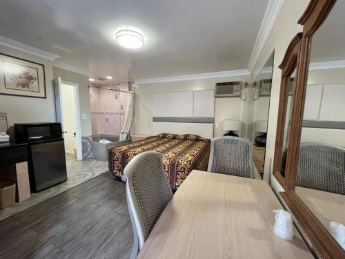 a hotel room with a bed and a table and chairs at Flamingo Motel Oxnard in Oxnard
