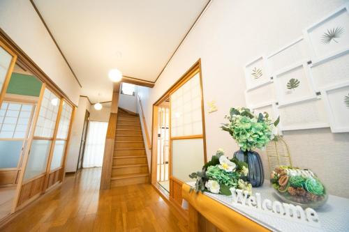 a hallway with a vase of flowers on a table at Awaji egaosakuie tonouchi in Awaji