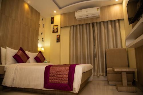 a hotel room with a bed and a window at Buddha Imperial in Muzaffarpur