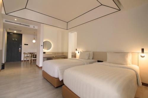 a hotel room with two beds and a table at GAIA Cosmo Hotel in Yogyakarta